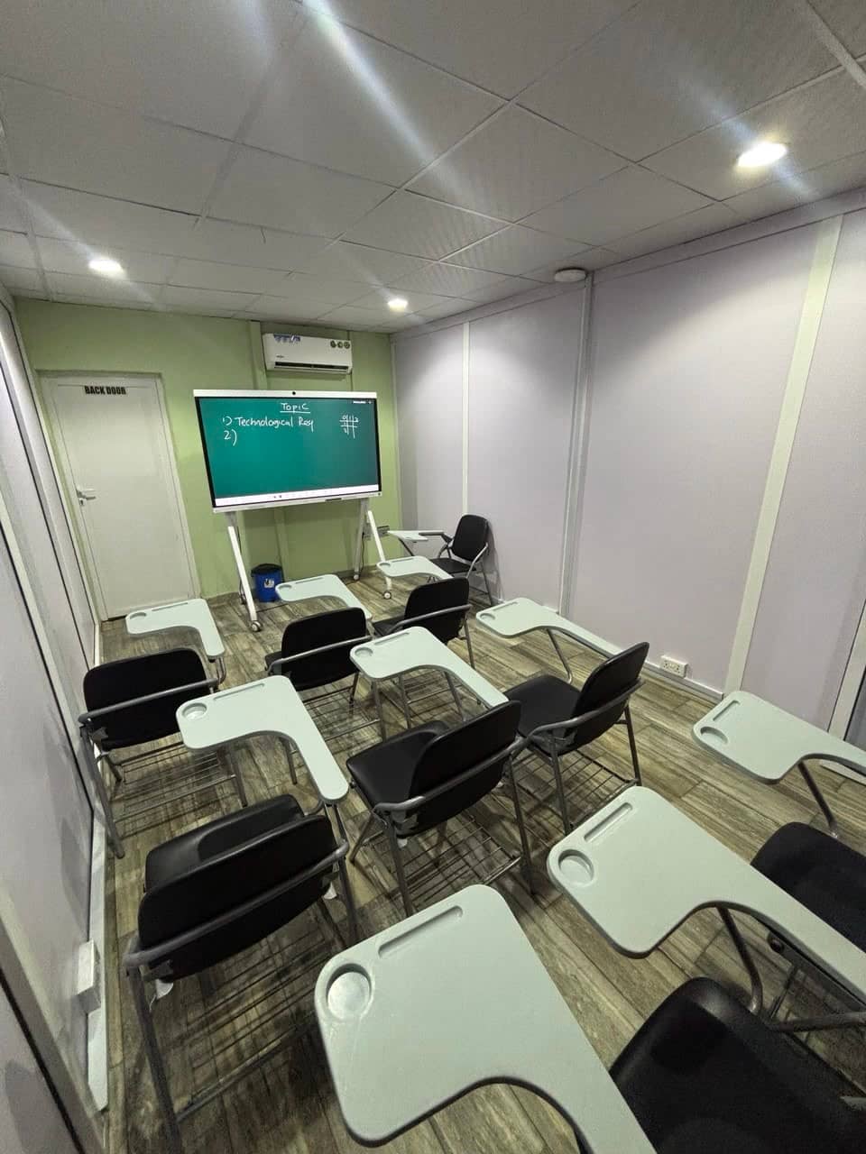 A class hall with writing-tablet chairs and an interactive screen